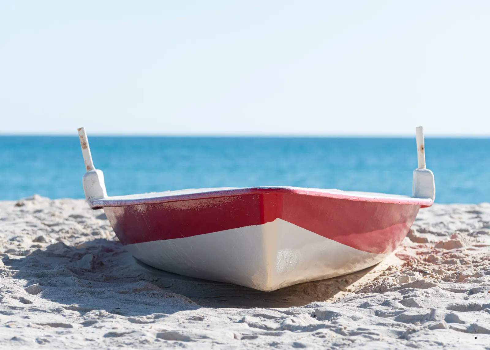 Traditional red-and-white fishing boat on a Cap Bon beach near Hammamet