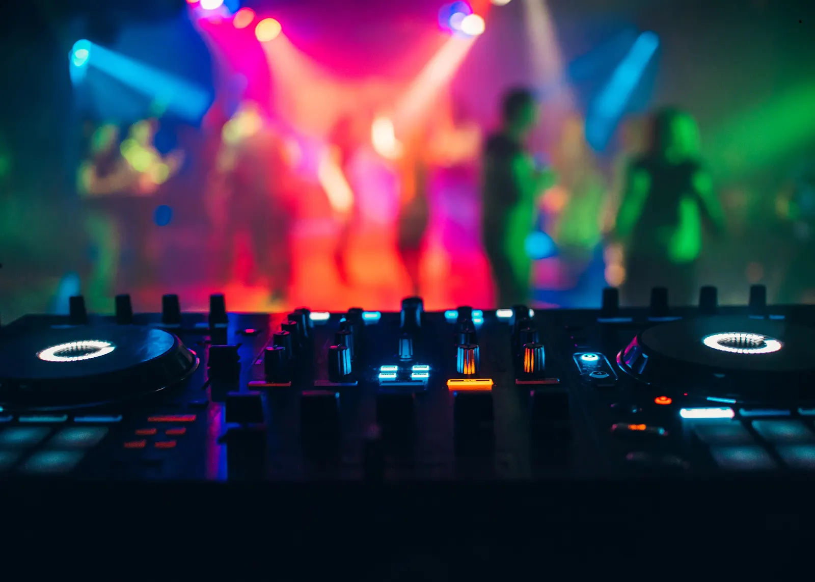 DJ booth glowing in front of a packed Tunisian club dancefloor