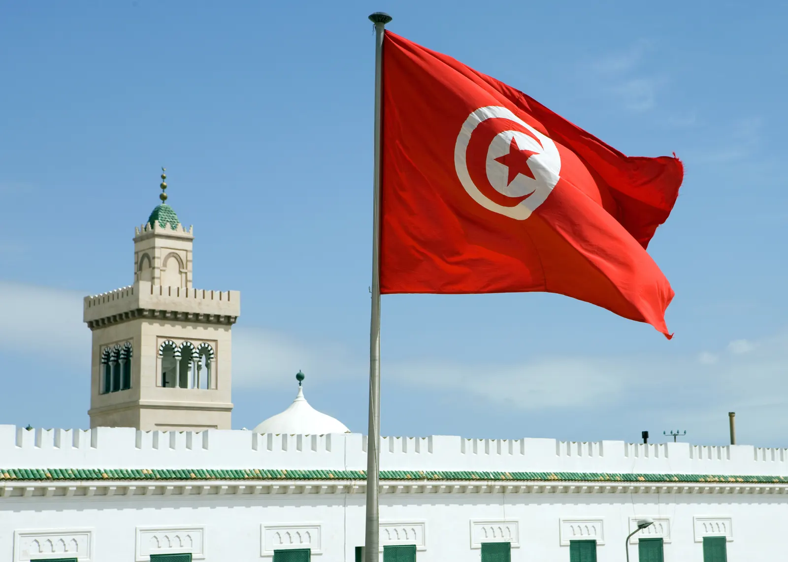 The Tunisian flag flying over a government building in Tunis